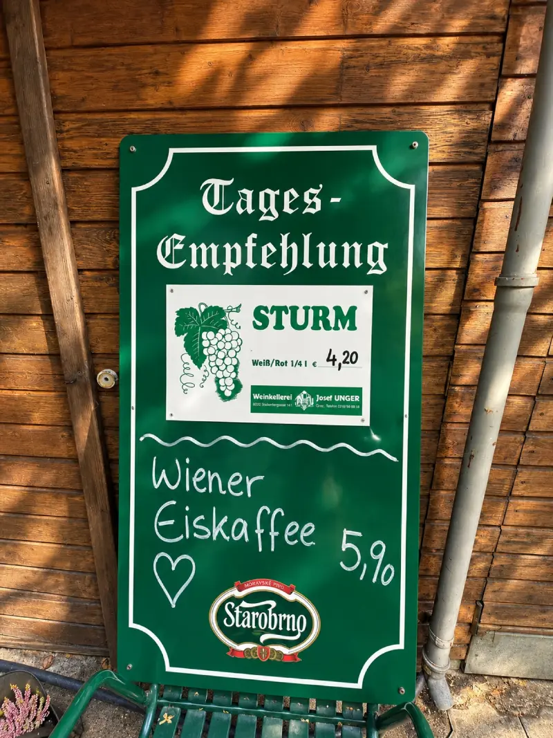 Handgeschriebene Tafel „Tages-Empfehlung“ mit Sturm um € 4,20 und Wiener Eiskaffee um € 5,90